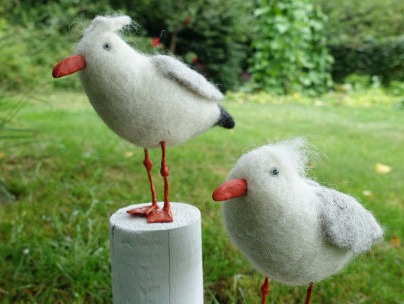 Zwei  gefilzte Möwen stehen im Garten