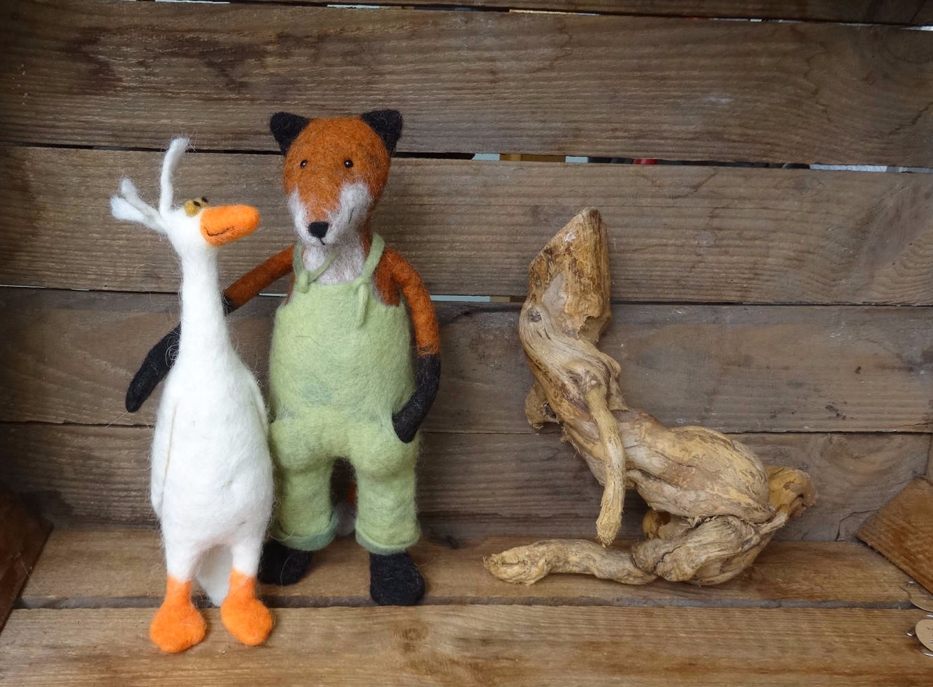 Ein gefilzter Fuchs mit grüner Latzhose und eine weiße gefilzte Gans