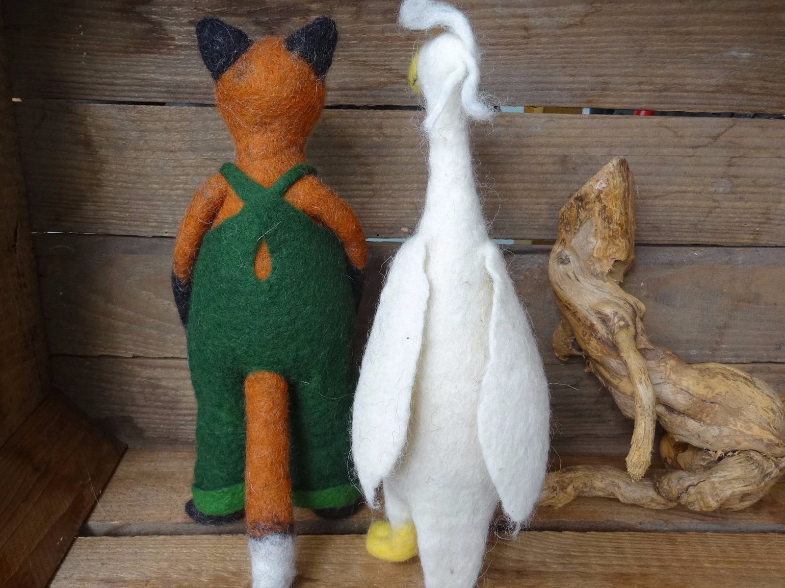 Gefilzter Fuchs mit grüner  Latzhose und eine weiße, gefilzte Gans von hinten