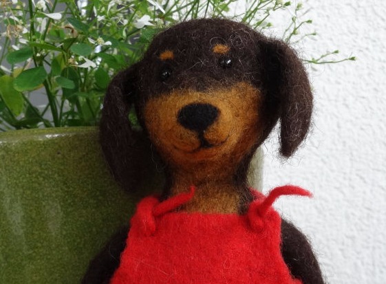 Gefilzter Dackelhund mit roter Latzhose