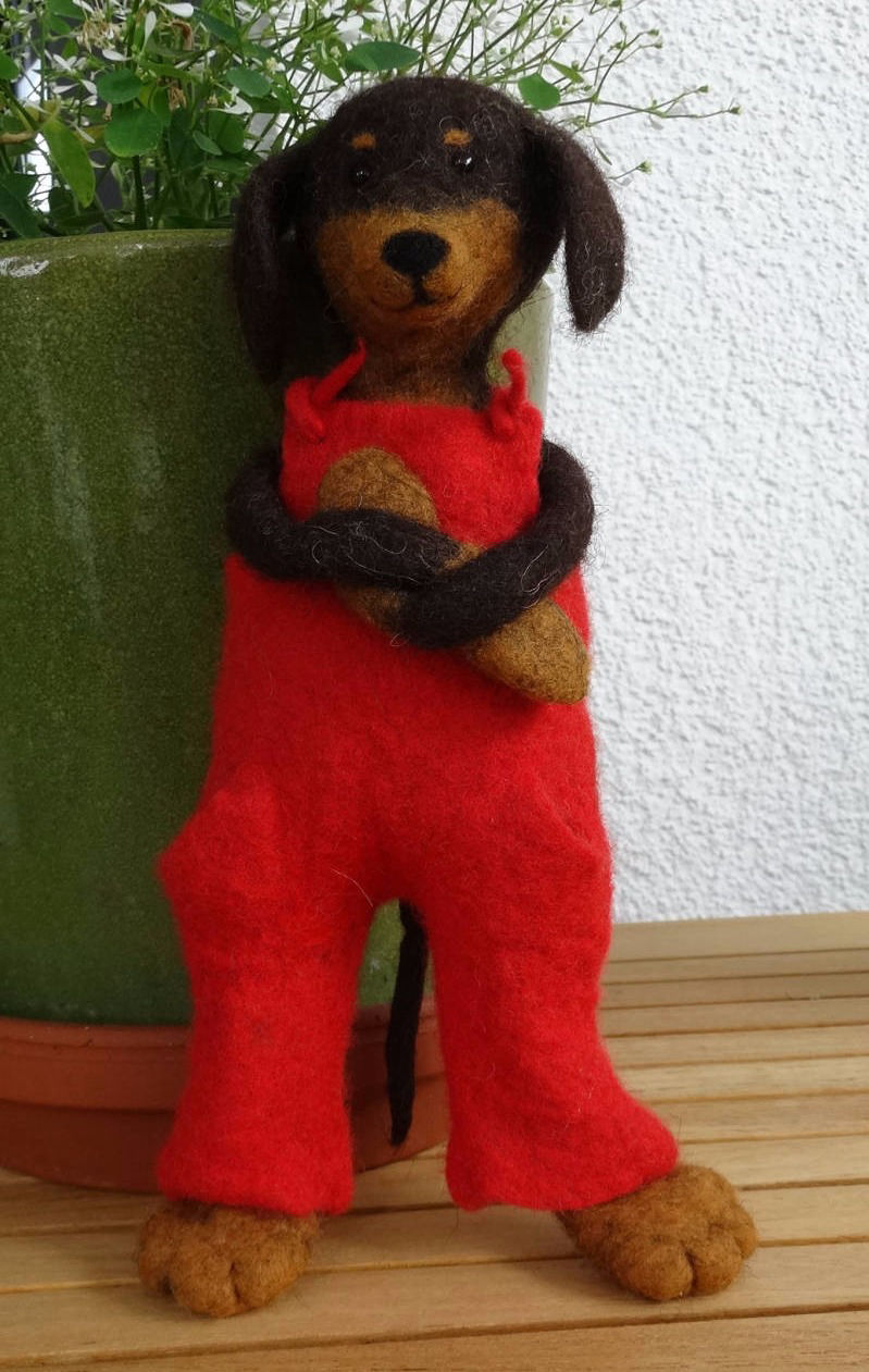 Ein gefilzter Dackel mit roter Latzhose
